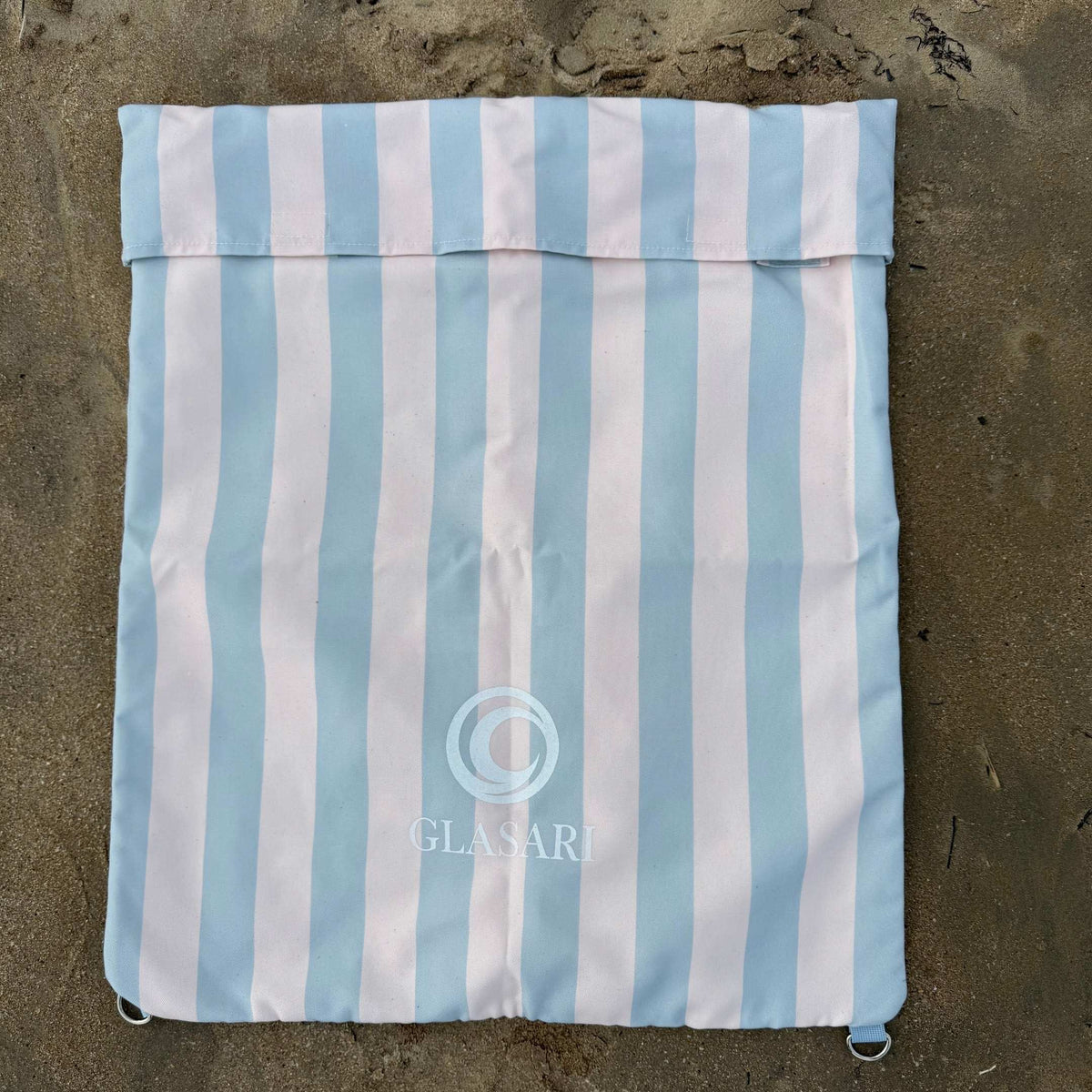 GLASARI Beach Buddy Vault in Blue Horizon stripe laid flat and empty, showing its full size, fold-over top and D-rings at each corner
