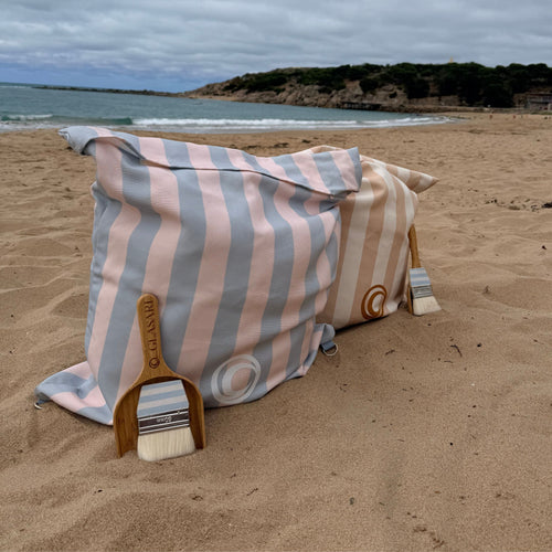 GLASARI Beach Buddy Vault in Blue Horizon stripe and Coastal Sand stripe on the sand at Horseshoe Bay, Port Elliot, with bamboo scoops and brushes