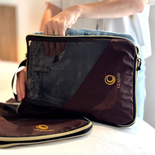 GLASARI Compressi-Cubes in Cocoa Drift, jeans being packed into a mesh-front cube with the gold GLASARI logo