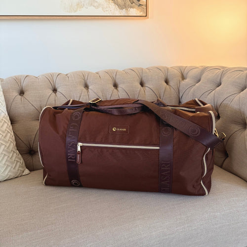 GLASARI Retreat Duffle in Cocoa Drift brown, styled on a lounge in a living room setting