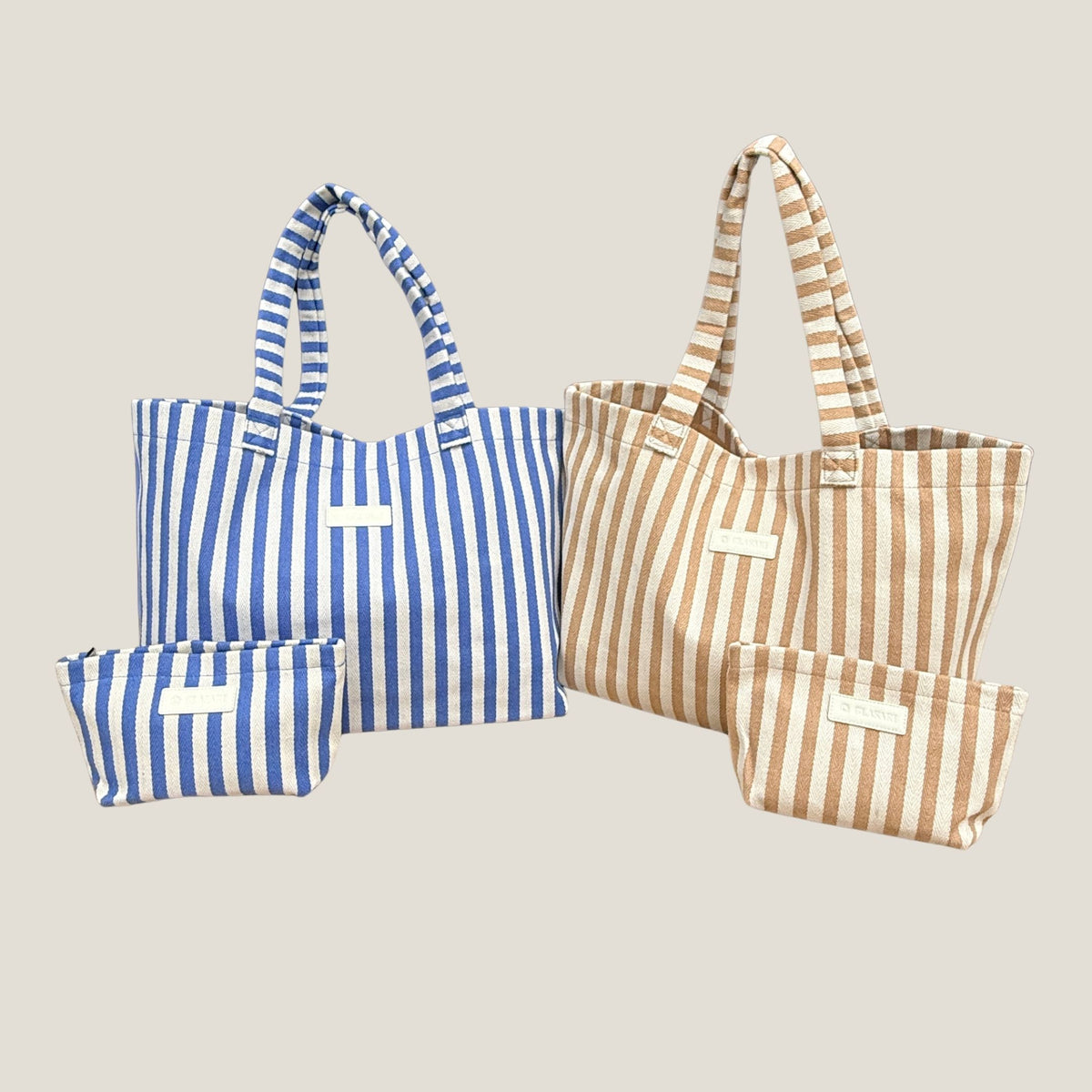 Both GLASARI Shore Tote colourways side by side, Ocean Blue Stripe and Sand Dune Stripe, each with its matching zip pouch